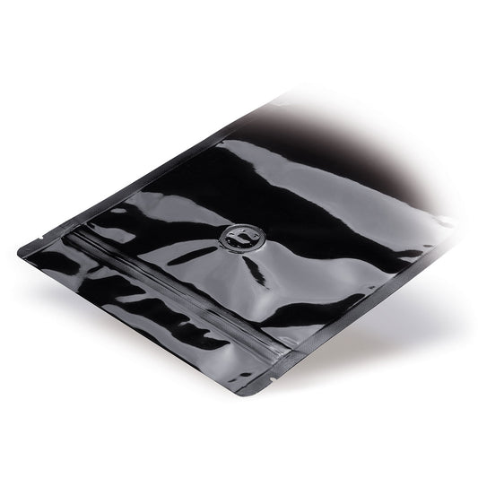 Sachet doypack noir avec valve d'arôme — vue détaillée dans une application d'emballage typique avec exemple de contenu